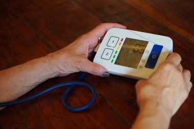 Yüksek tansiyon. Kan basıncı düşük. Tıbbi kavramlar. Tansiyonunu ölçen meçhul yaşlı İskandinav kadın.