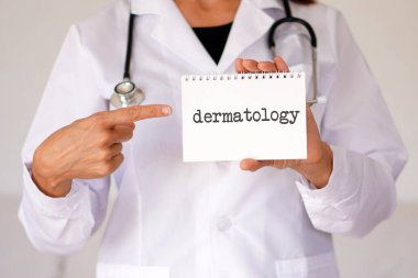 Tıbbi terimler. Dermatoloji. Kadın doktor tıbbi not defterindeki kelimeyi işaret ediyor.