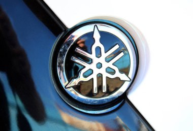 Vinnytsia, Ukraine; September 06, 2025. Close up black Yamaha logo. Close-up of glossy black and chrome Yamaha emblem. Yamaha Motor Company logo and emblem. Emblem features intersecting tuning forks.