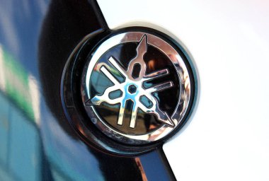 Vinnytsia, Ukraine; September 06, 2025. Close up black Yamaha logo. Close-up of glossy black and chrome Yamaha emblem. Yamaha Motor Company logo and emblem. Emblem features intersecting tuning forks.