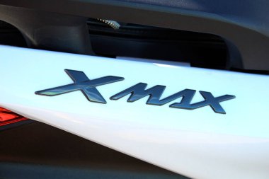 Vinnytsia, Ukraine; September 06, 2025. Close-up of Yamaha Xmax badge in glossy black finish on white surface of Yamaha scooter. Letters are stylized and reflect light with metallic sheen.