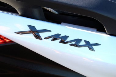 Vinnytsia, Ukraine; September 06, 2025. Close-up of Yamaha Xmax badge in glossy black finish on white surface of Yamaha scooter. Letters are stylized and reflect light with metallic sheen.