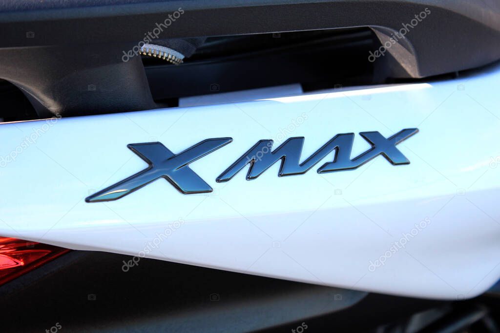 Vinnytsia, Ukraine; September 06, 2025. Close-up of Yamaha Xmax badge in glossy black finish on white surface of Yamaha scooter. Letters are stylized and reflect light with metallic sheen.