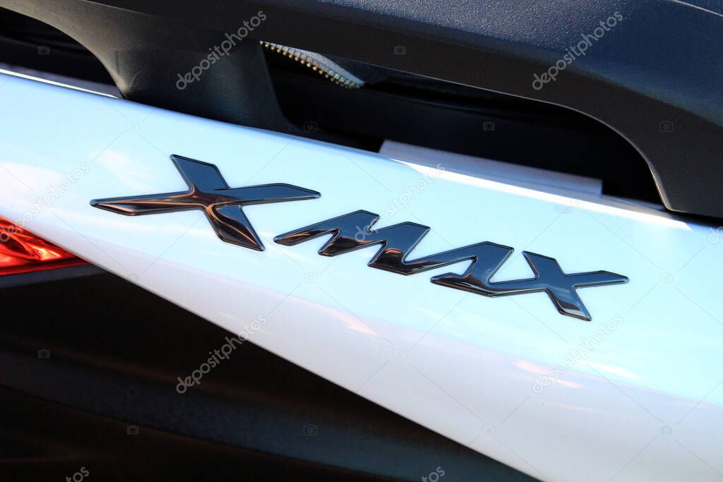 Vinnytsia, Ukraine; September 06, 2025. Close-up of Yamaha Xmax badge in glossy black finish on white surface of Yamaha scooter. Letters are stylized and reflect light with metallic sheen.