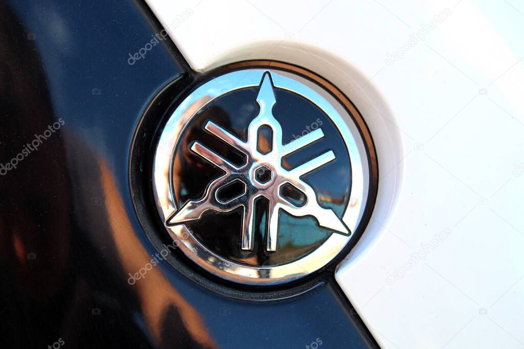 Vinnytsia, Ukraine; September 06, 2025. Close up black Yamaha logo. Close-up of glossy black and chrome Yamaha emblem. Yamaha Motor Company logo and emblem. Emblem features intersecting tuning forks.