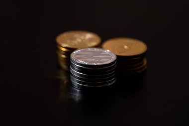 Siyah arka planda Bitcoin, Ethereum ve Litecoin 'i temsil eden metalik altın ve gümüş paralarla kripto para birimi. Kripto yatırımları, dijital zenginlik, engelleme eğilimleri ve ekonomik bozulma