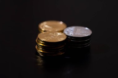 Siyah arka planda Bitcoin, Ethereum ve Litecoin 'i temsil eden metalik altın ve gümüş paralarla kripto para birimi. Kripto yatırımları, dijital zenginlik, engelleme eğilimleri ve ekonomik bozulma