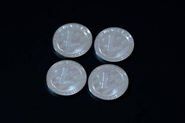 Koyu bir yüzeye yerleştirilmiş sikkeler Litecoin. Dijital varlıklar ve engelleme teknolojisi. Fintech, engelleme zinciri, kripto ticareti veya yatırımla ilgili medyada kullanım için ideal.