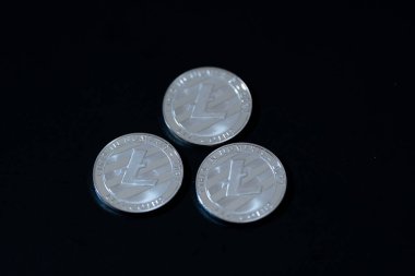 Koyu bir yüzeye yerleştirilmiş sikkeler Litecoin. Dijital varlıklar ve engelleme teknolojisi. Fintech, engelleme zinciri, kripto ticareti veya yatırımla ilgili medyada kullanım için ideal.