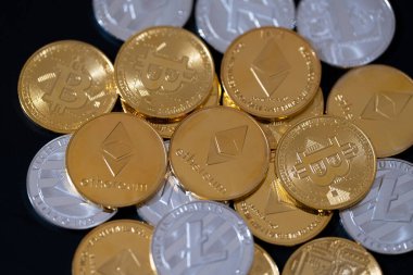 Siyah arka planda Bitcoin, Ethereum ve Litecoin 'i temsil eden metalik altın ve gümüş paralarla kripto para birimi. Kripto yatırımları, dijital zenginlik, engelleme eğilimleri ve ekonomik bozulma