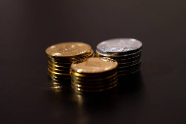 Siyah arka planda Bitcoin, Ethereum ve Litecoin 'i temsil eden metalik altın ve gümüş paralarla kripto para birimi. Kripto yatırımları, dijital zenginlik, engelleme eğilimleri ve ekonomik bozulma