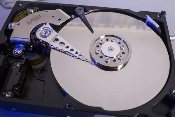 Hard disk drive platter. Open hdd hard disk. Data recovery from damaged media. Disk head above the plates