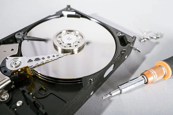 Hard disk drive platter. Open hdd hard disk. Data recovery from damaged media. Disk head above the plates