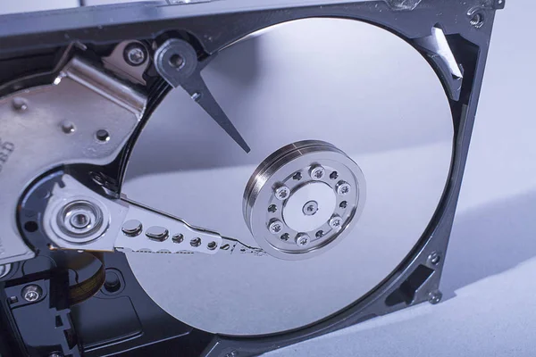 Hard disk drive platter. Open hdd hard disk. Data recovery from damaged media. Disk head above the plates