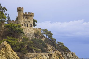 Bir Lloret de Mar / İspanya - 27 Haziran 2018: Castell d'en Plajan Costa Brava ve şehir beach Lloret de Mar, İspanya. Kum ve deniz dalgaları.