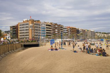 Bir Lloret de Mar / İspanya - 27 Haziran 2018: sahil Lloret de kumlu ve kayalık Katalanca plajlar Costa Brava Mar. kumsalda güzel bir şehir. Playa de Lloret, Akdeniz kumsalda insanlar.