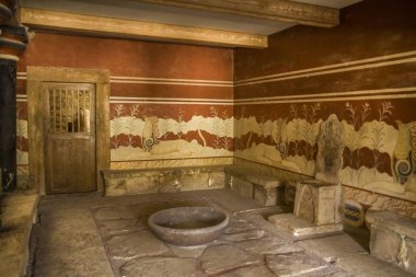 Girit/Yunanistan - 27 Eylül 2018: Knossos Sarayı, taht odasında. Duvarları antik fresklerle dekore edilmiştir. Kraliyet tahtının önünde gizemli bir kase.