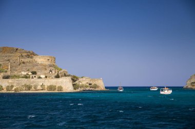 Spinalonga adası gezisi. Küçük tekne mavi lagün. Spinalonga Crete, Yunanistan adada Kalesi. Adada mimarisi.