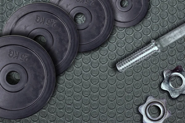 哑铃和重物躺在体育馆的地板上 杠铃和健身器材 健身俱乐部中的金属负荷 — 图库照片
