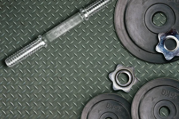哑铃和重物躺在体育馆的地板上 杠铃和健身器材 健身俱乐部中的金属负荷 — 图库照片