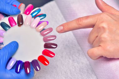 Bakımı ve manikür çivi. Closeup şeffaf oje güzellik salonu sağlıklı doğal kadının çivi uygulayarak güzel eller. Manikürcü el boyama müşterinin çivi