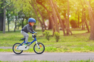 Mutlu çocuk çocuk 5 yıllık güzel sonbahar gününde bahar Park bir bisiklet ile eğleniyor. Etkin alt giyen Bisiklet kask