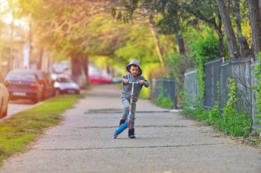 Çocuk parkta eğleniyor scooter ile