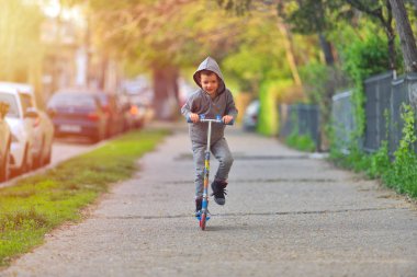 Çocuk parkta eğleniyor scooter ile