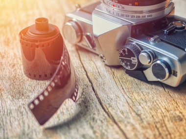 Eski retro 35mm film Slr fotoğraf makinesi ile fotoğraf filmi ahşap bir masaya oturan yakın çekim