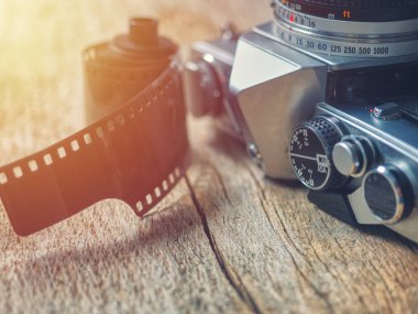 Eski retro 35mm film Slr fotoğraf makinesi ile fotoğraf filmi ahşap bir masaya oturan yakın çekim
