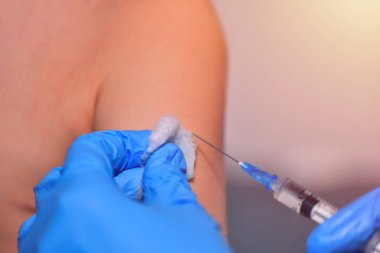 Yakın çekim yakışıklı doktor veya hemşire hastaya şırınga enjekte üst kol istimal tedavi için aşı vardır. Doktor iğne bir hastaya verilmesi