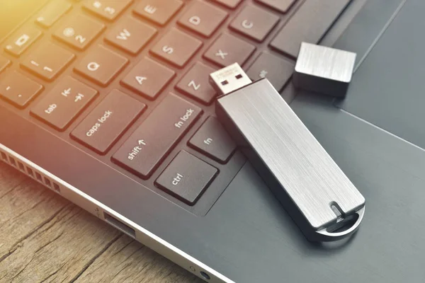 Nahaufnahme von Metall-USB-Stick mit Laptop auf Holz Schreibtisch verbunden — Stockfoto