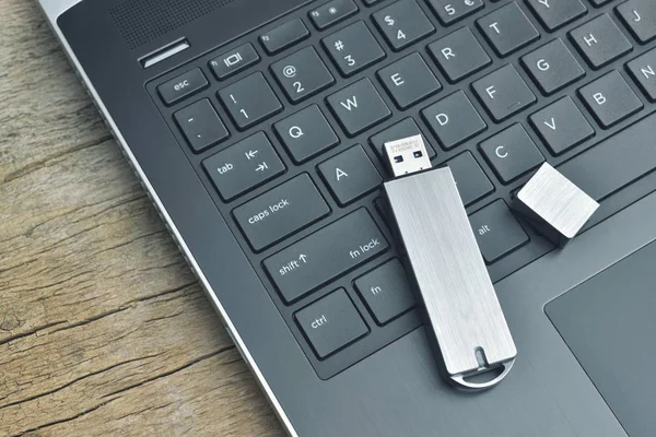 Nahaufnahme von Metall-USB-Stick mit Laptop auf Holz Schreibtisch verbunden — Stockfoto