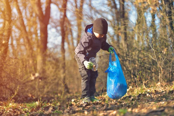 Çöp tenekesini geri dönüşümlü çöp çöpü temizleme eğitimi. Doğa temizliği, gönüllü ekoloji yeşil kavramı. Genç erkekler ve çocuklar bahar ormanlarını gün batımında alırlar. Çevre plastik kirliliği
