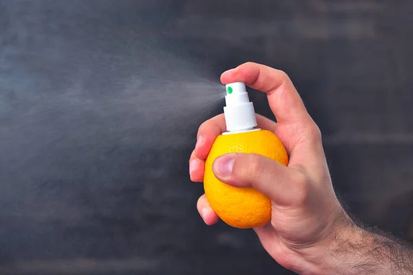 Man sprinkles juice from lemon with help of pump for spray. Healthy food and vitamins. Lemon juice spray concept