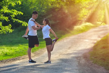 Parkta bir yolda bacaklar germe genç çift