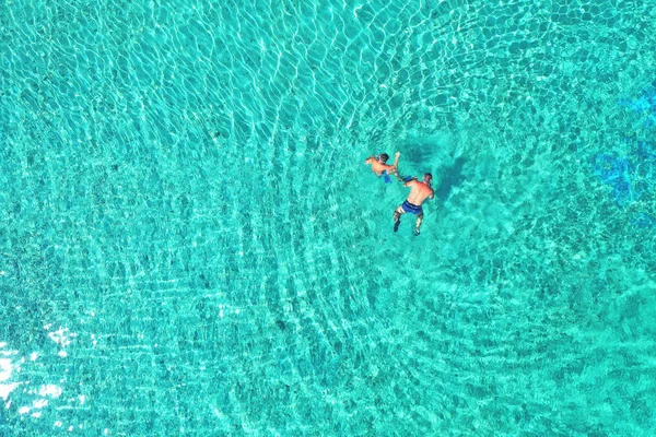 Padre e hijo bucean a través de aguas tropicales, turquesas, vista aérea —  Fotos de Stock