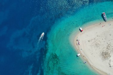 Berrak su, kumlu kıyı ve Caretta-Caretta deniz kaplumbağalarının doğal kuluçka hanesi, Zakynthos, Yunanistan'ın ikonik küçük ıssız Marathonisi adasının havadan insansız hava aracı görünümü