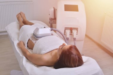 Güzel genç bir kadın kozmetik kabinesinde tedavi görüyor.