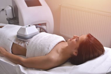 Güzel genç bir kadın kozmetik kabinesinde tedavi görüyor.