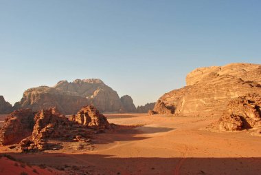Wadi Rum Çölü 'nün akşam manzarası. Kum taşı kayaları ve kum vadisi.