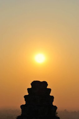 Akşam güneşi Angkor 'daki Phnom Bakheng tapınağının eski kulesinde.