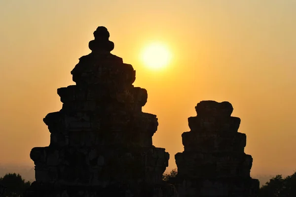 Angkor 'daki Phnom Bakheng tapınağının tepesinde akşam güneşi.