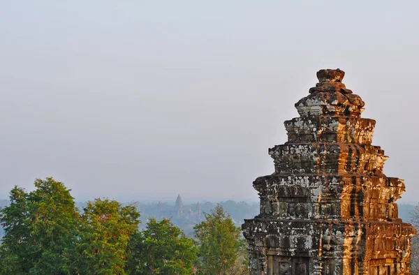 İyi akşamlar Angkor. Phnom Bakheng tapınak kulesi ve Angkor Wat ufukta.