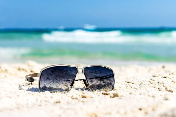 Close up sunglasses on tropical beach and white sandy background