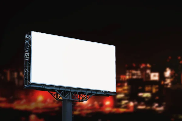 Cartelera en blanco maqueta con pantalla blanca fondo de la ciudad de noche . —  Fotos de Stock