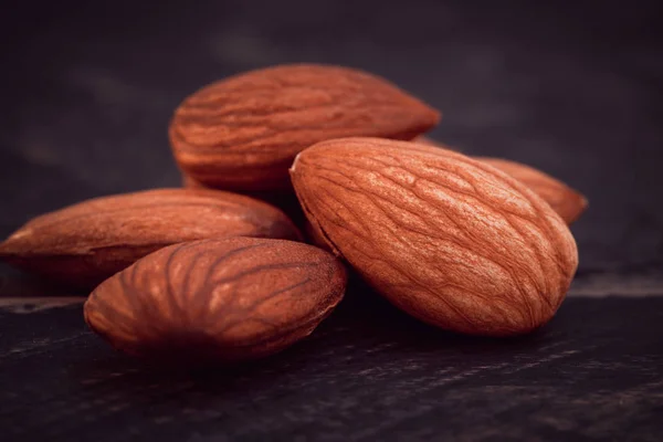 Close up raw peeled almonds seed  wooden background. — Stock Photo, Image