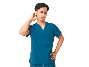 Kafasını kaşıyan önlüklü, stresli, genç Asyalı erkek hemşire beyaz arka planda izole edilmiş, kafası karışık ve üzgün bir ifade sergiliyor..