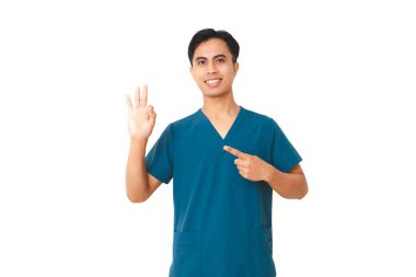 Üzerinde steteskopla gülümseyen genç erkek hemşire beyaz arka planda izole edilmiş, kamerada üç parmak hareketi gösteriyor..