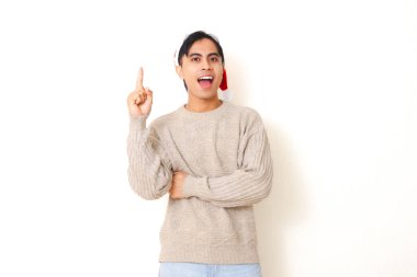 Heyecanlı genç Asyalı adam Noel Baba şapkası takıyor parlak fikir ifadesiyle yukarıya bakıyor, beyaz arka planda izole edilmiş, Noel kutlaması ve tatil konsepti için mükemmel..